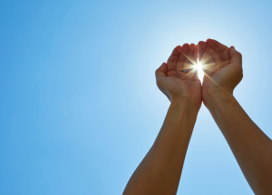 Traitements laser en été : est-ce vraiment possible ? 1 a pair of hands holding the sun